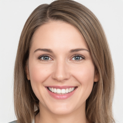 Joyful white young-adult female with long  brown hair and grey eyes