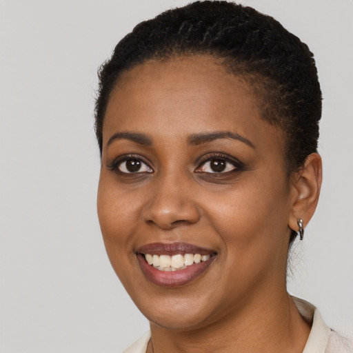Joyful black young-adult female with short  black hair and brown eyes
