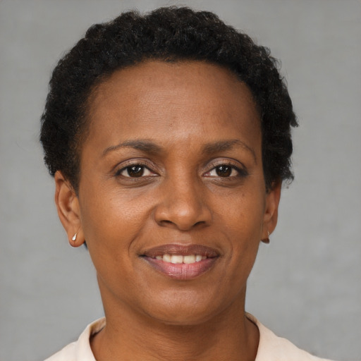 Joyful black adult female with short  brown hair and brown eyes