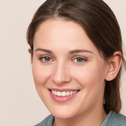 Joyful white young-adult female with medium  brown hair and grey eyes