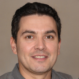 Joyful white adult male with short  brown hair and brown eyes