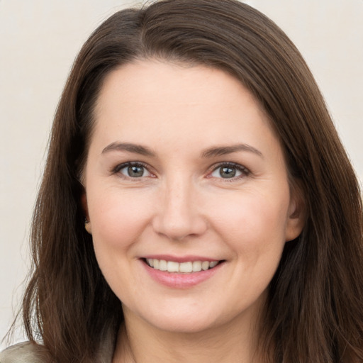 Joyful white young-adult female with long  brown hair and brown eyes