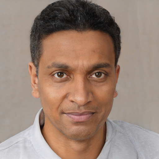 Joyful black adult male with short  black hair and brown eyes