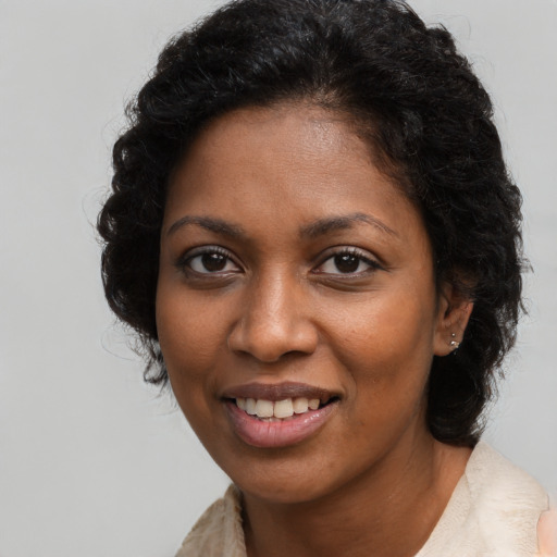 Joyful black young-adult female with long  brown hair and brown eyes
