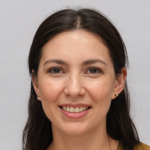 Joyful white young-adult female with long  brown hair and brown eyes