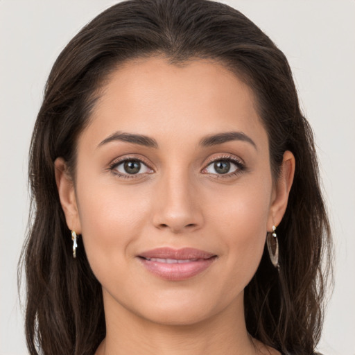 Joyful white young-adult female with long  brown hair and brown eyes