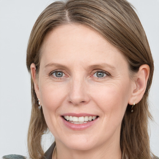 Joyful white adult female with medium  brown hair and blue eyes