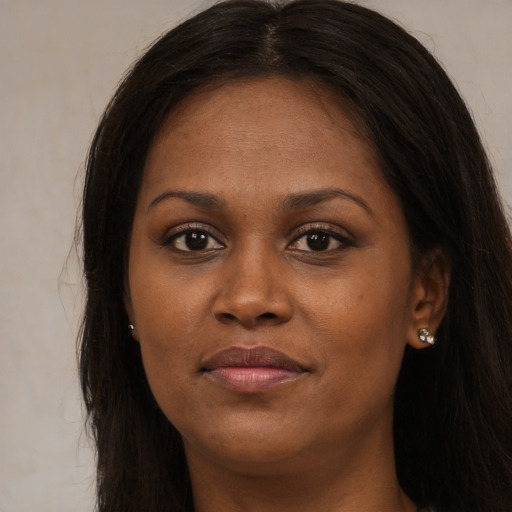 Joyful black young-adult female with long  brown hair and brown eyes