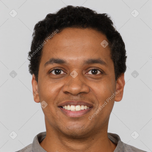 Joyful black young-adult male with short  black hair and brown eyes