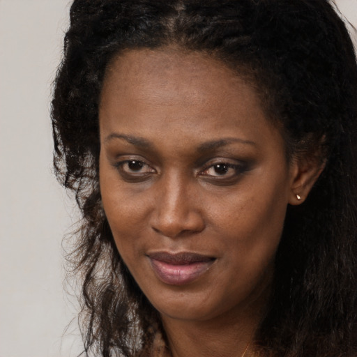 Joyful black young-adult female with long  brown hair and brown eyes