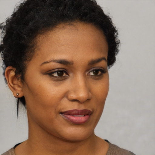 Joyful black young-adult female with short  brown hair and brown eyes