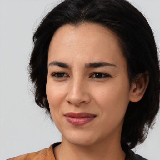 Joyful latino young-adult female with medium  brown hair and brown eyes
