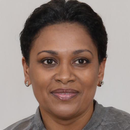 Joyful black adult female with short  brown hair and brown eyes