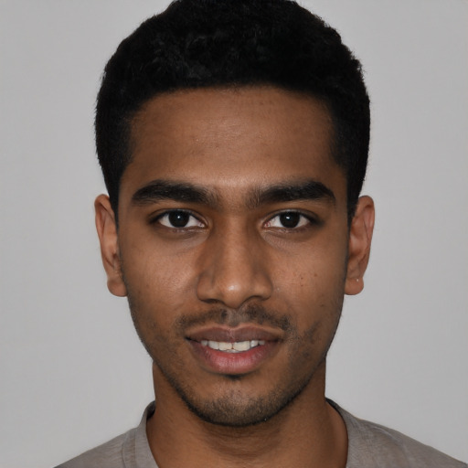 Joyful black young-adult male with short  black hair and brown eyes