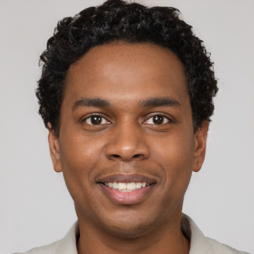 Joyful black young-adult male with short  black hair and brown eyes