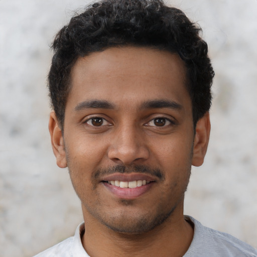 Joyful latino young-adult male with short  brown hair and brown eyes