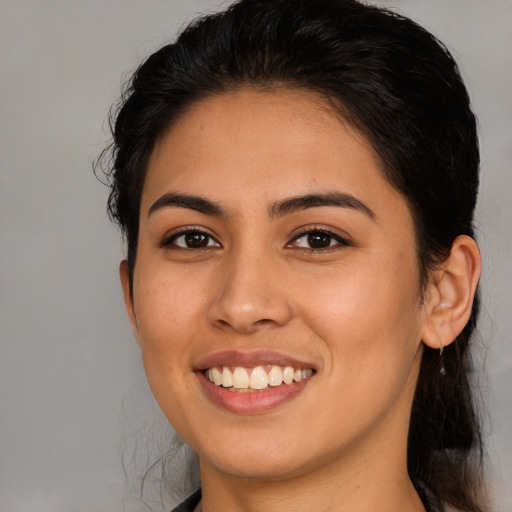 Joyful latino young-adult female with medium  brown hair and brown eyes