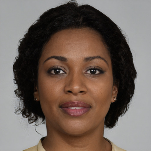 Joyful black young-adult female with medium  brown hair and brown eyes
