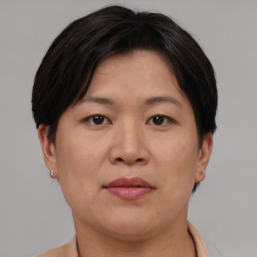 Joyful asian adult female with short  brown hair and brown eyes