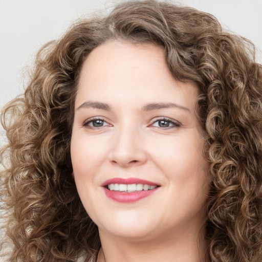 Joyful white young-adult female with long  brown hair and green eyes