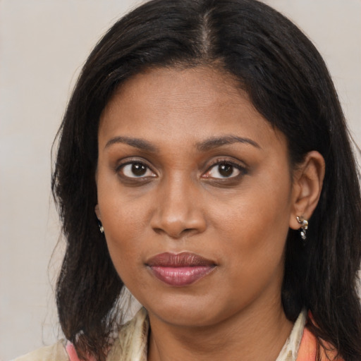 Joyful black young-adult female with long  brown hair and brown eyes