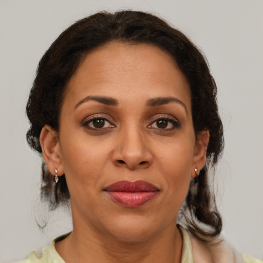 Joyful latino adult female with medium  brown hair and brown eyes