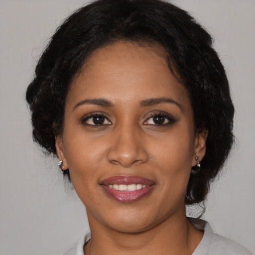 Joyful black young-adult female with medium  black hair and brown eyes