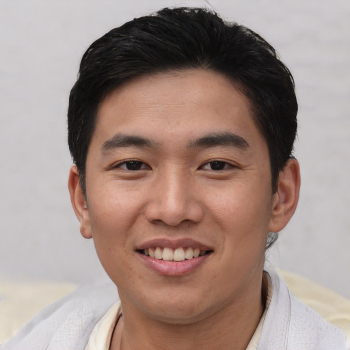 Joyful asian young-adult male with short  brown hair and brown eyes