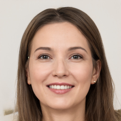 Joyful white young-adult female with long  brown hair and grey eyes