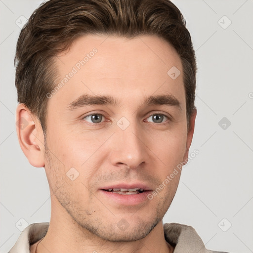 Joyful white young-adult male with short  brown hair and grey eyes