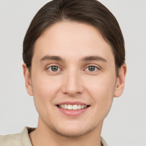 Joyful white young-adult male with short  brown hair and grey eyes