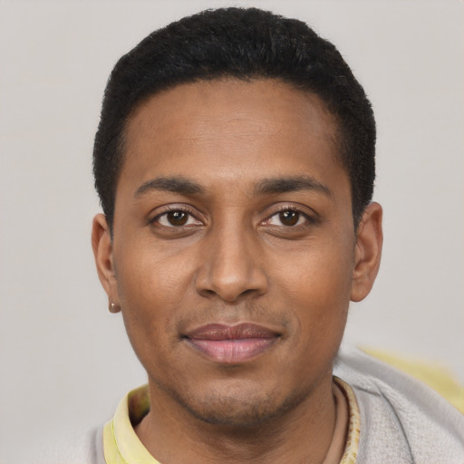 Joyful black young-adult male with short  black hair and brown eyes