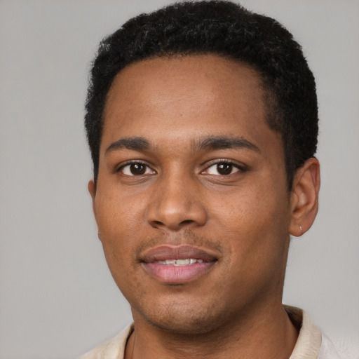 Joyful black young-adult male with short  brown hair and brown eyes