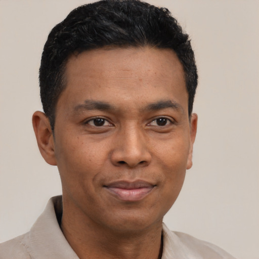 Joyful latino young-adult male with short  black hair and brown eyes
