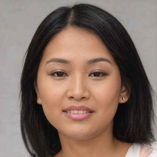 Joyful asian young-adult female with long  brown hair and brown eyes