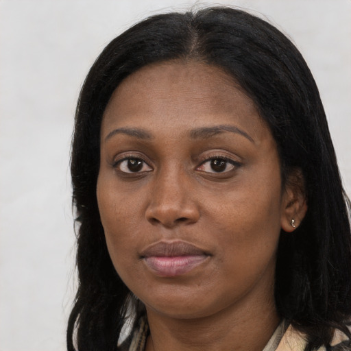 Joyful black young-adult female with long  brown hair and brown eyes
