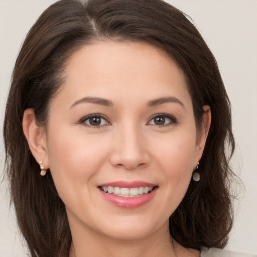 Joyful white young-adult female with long  brown hair and brown eyes