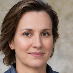 Joyful white adult female with medium  brown hair and grey eyes