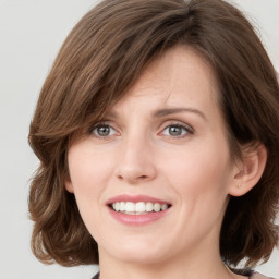 Joyful white young-adult female with medium  brown hair and green eyes