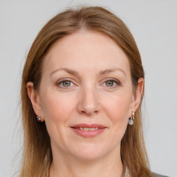 Joyful white adult female with long  brown hair and grey eyes