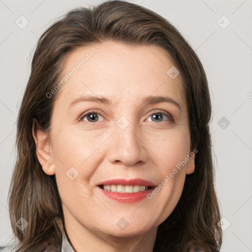 Joyful white adult female with long  brown hair and grey eyes