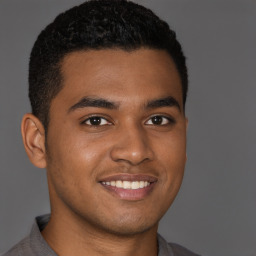 Joyful black young-adult male with short  brown hair and brown eyes