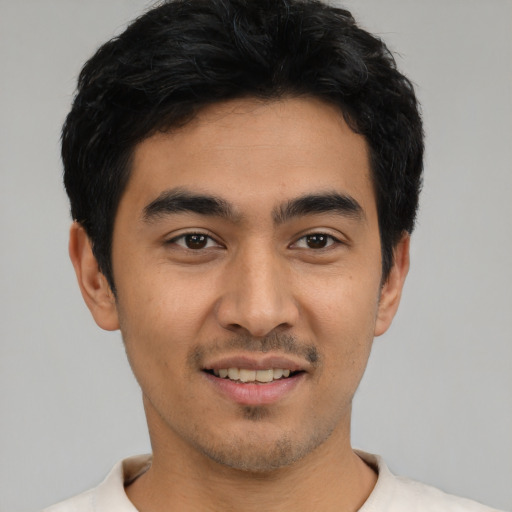 Joyful latino young-adult male with short  black hair and brown eyes