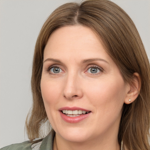 Joyful white adult female with medium  brown hair and grey eyes