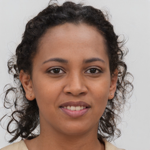 Joyful black young-adult female with long  brown hair and brown eyes