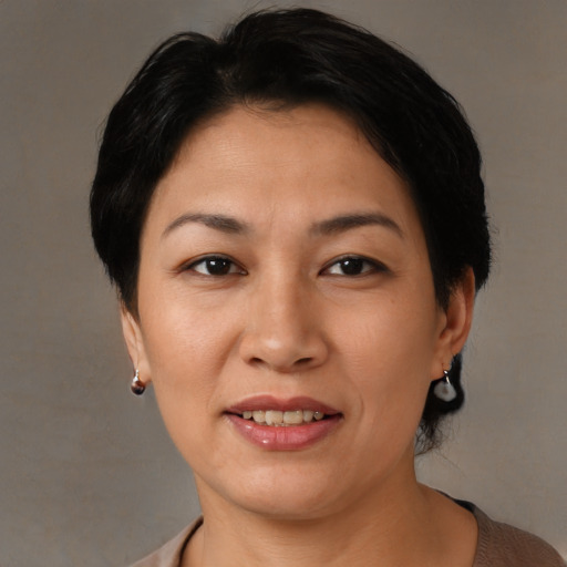 Joyful asian adult female with short  brown hair and brown eyes