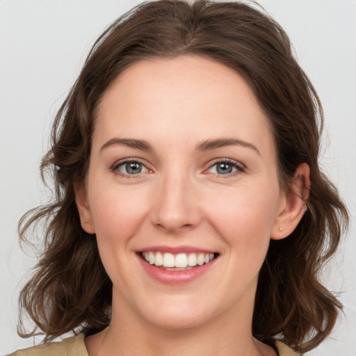 Joyful white young-adult female with medium  brown hair and green eyes