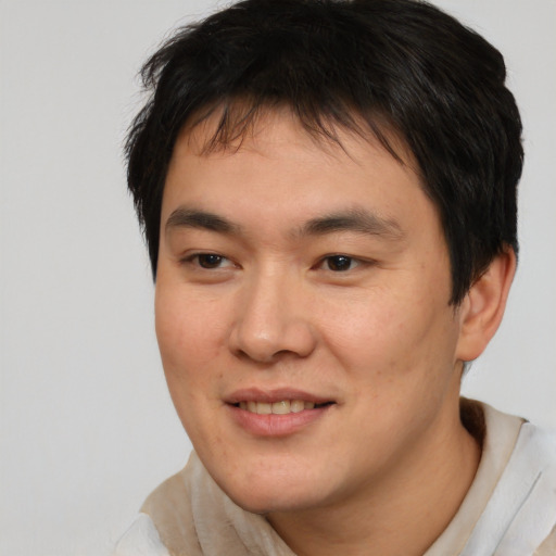 Joyful asian young-adult male with short  brown hair and brown eyes
