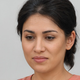 Joyful latino young-adult female with medium  brown hair and brown eyes