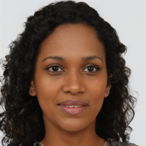 Joyful black young-adult female with long  brown hair and brown eyes